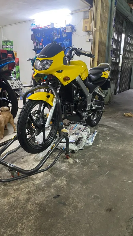 Honda LS 125 màu vàng đang lắp lại, nhìn phía trước