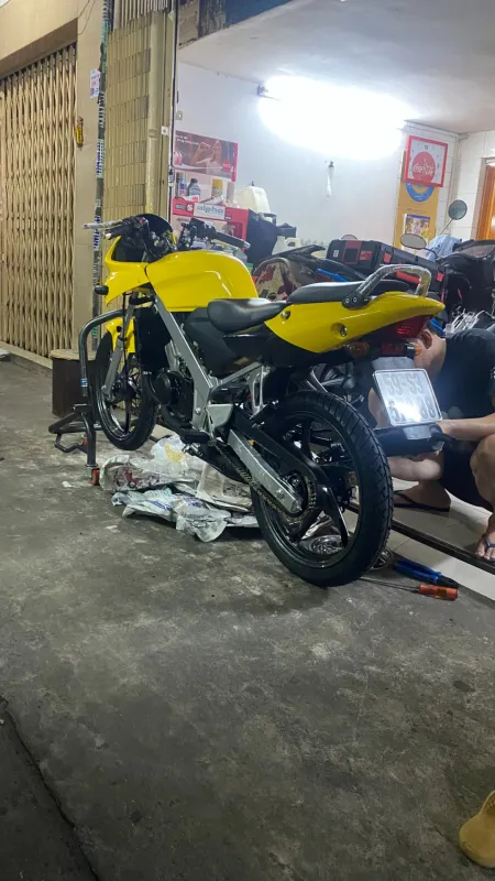 Honda LS 125 màu vàng đang lắp lại, nhìn phía sau